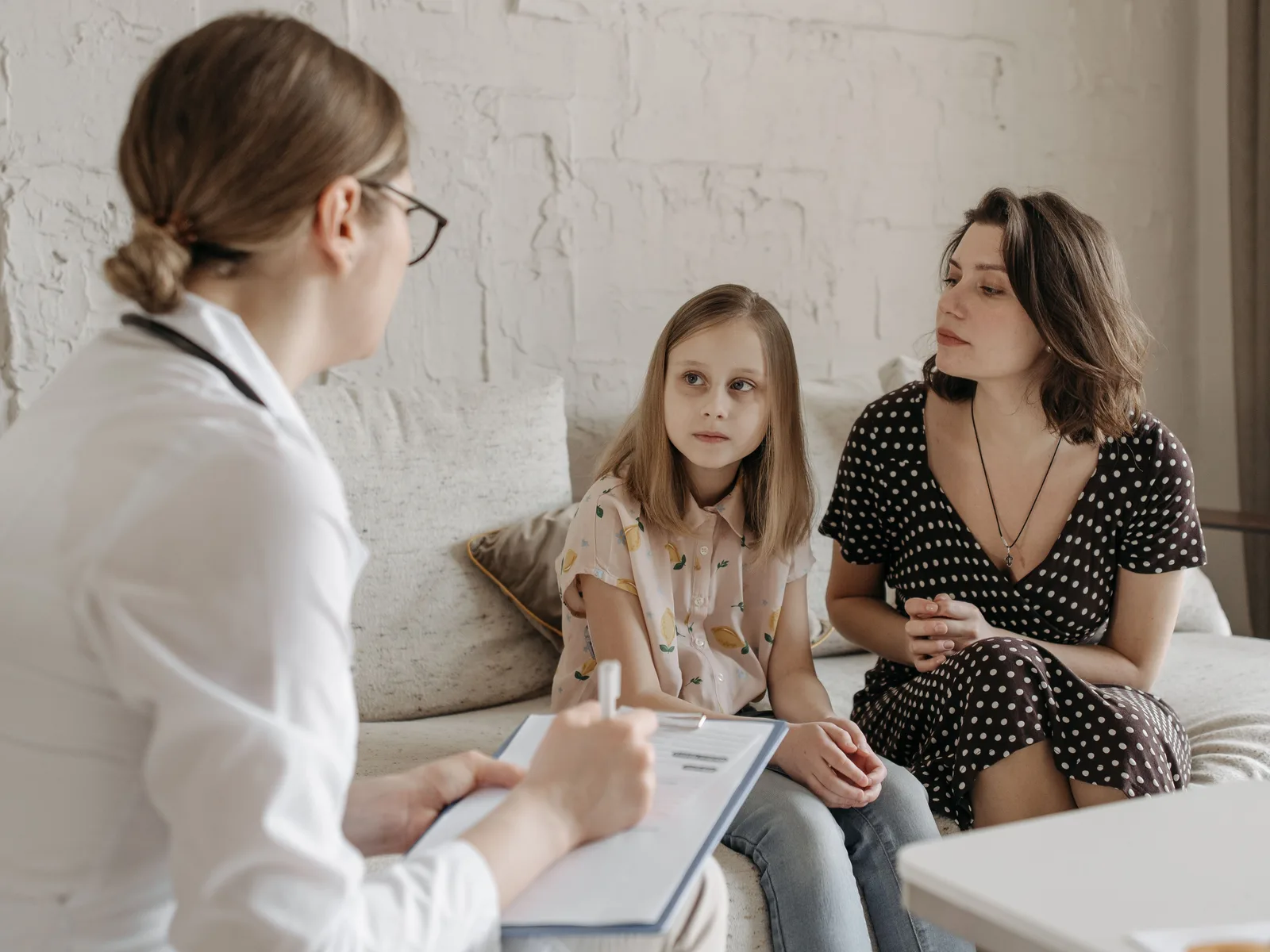 Mãe e filha em consulta com uma médica